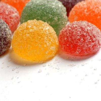 several different colored candies sitting on top of each other in front of a white background