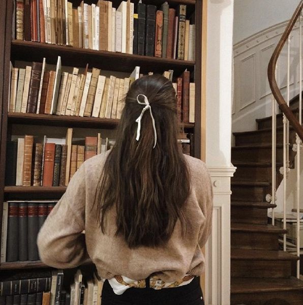 a woman standing in front of a bookshelf