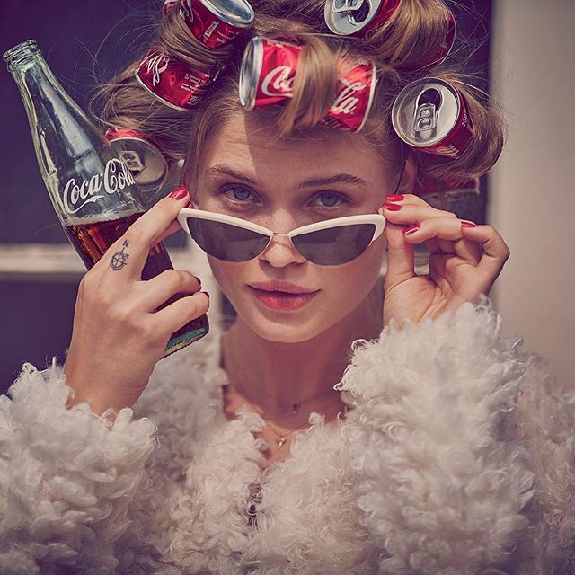 a woman with sunglasses and coca colas on her head