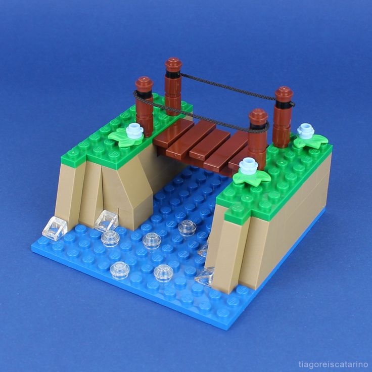 a lego bridge over a body of water with rocks and ice cubes on it