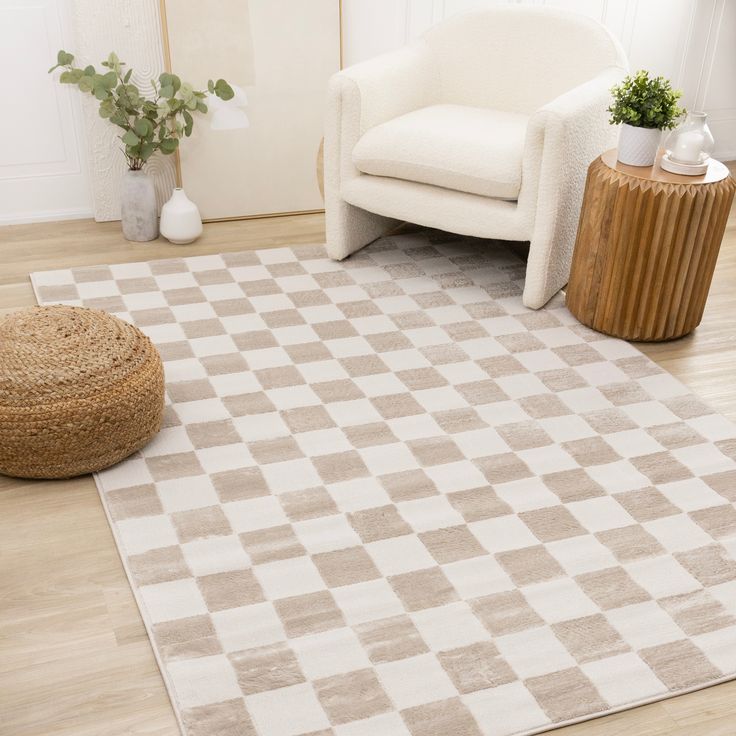 a living room with a checkered rug on the floor next to a chair and potted plant