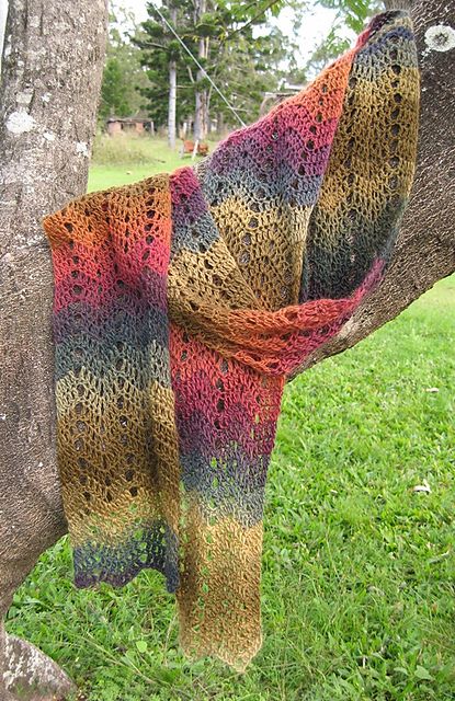 a knitted shawl hanging from a tree