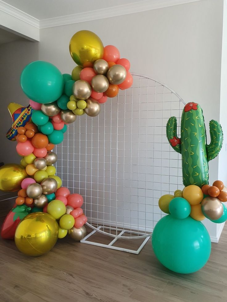 balloons are arranged in the shape of a cactus and other items for a balloon arch