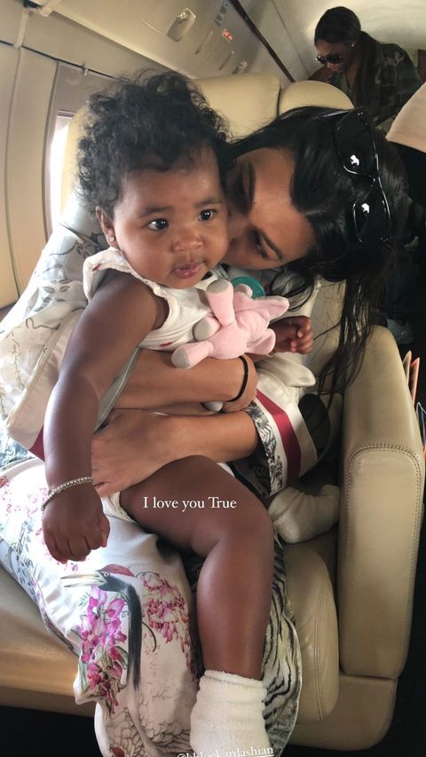 a woman holding a small child in her lap while sitting on the back of an airplane