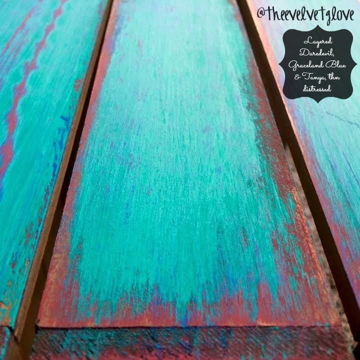 an old wooden table with blue and green paint