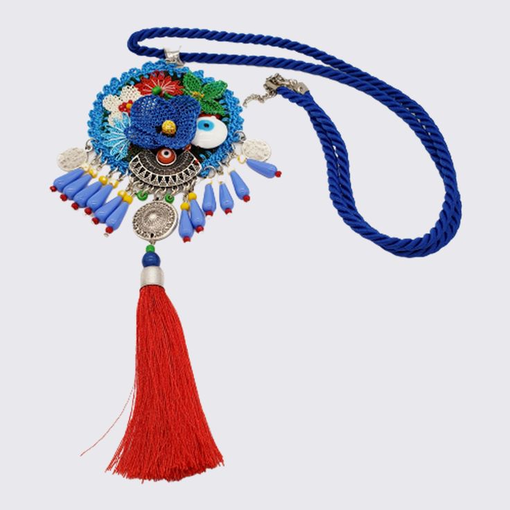 A central medallion depicts a beautiful scene of flowers in vibrant colors. Beads of different shapes and textures dangle among intricate open-work charms. The look is finished with a luxurious dangling tassel. Each piece is crafted from a combination of felt, delicate needle lacework and beads. Pair these stunning necklaces with a plain white shirt that will make it the focal point of your look. Add a wow-factor to your little black dress and create a carefree style-statement with jeans and a b Blue Bohemian Beaded Necklaces With Tassels, Bohemian Blue Beaded Necklaces With Tassels, Blue Bohemian Tassel Necklace For Gift, Bohemian Blue Beaded Necklace For Festivals, Adjustable Blue Bohemian Tassel Necklace, Blue Bohemian Medallion Necklace, Bohemian Blue Medallion Necklace, Handmade Blue Adjustable Tassel Necklace, Handmade Adjustable Blue Tassel Necklace