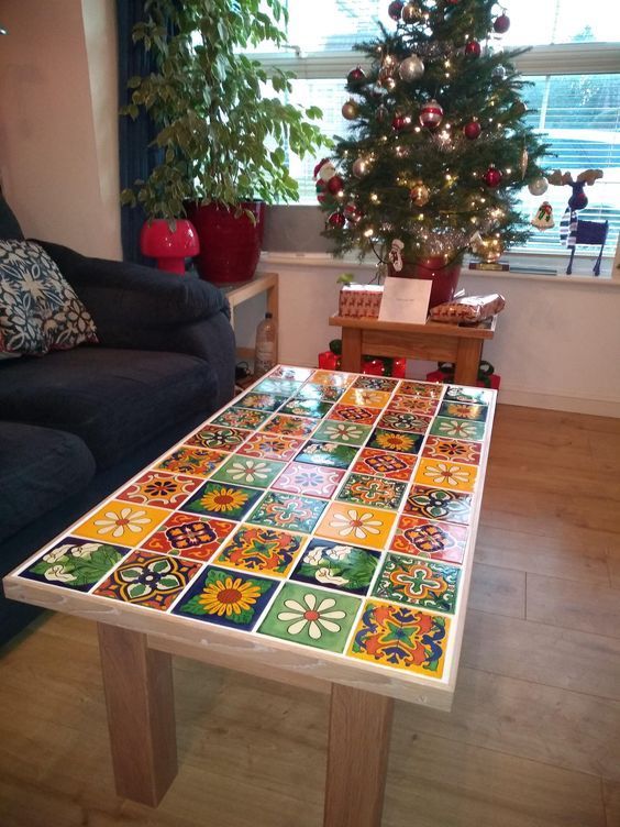 a living room with a christmas tree in the corner and colorful tiles on the table