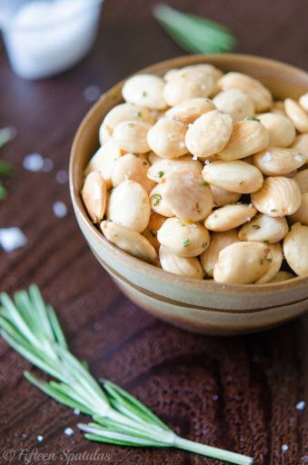 a wooden bowl filled with cashews on top of a table