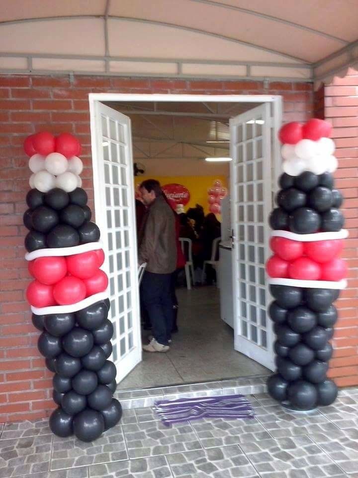 an entrance decorated with black, white and red balloons