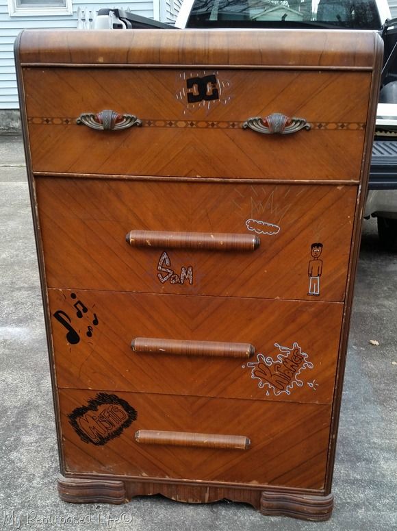 an old wooden dresser with stickers on it's sides and eyes drawn on the drawers