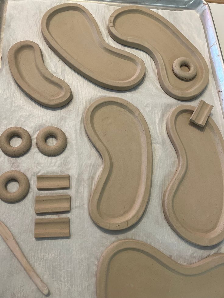 clay shapes and tools sitting on top of a sheet of waxed paper, ready to be made