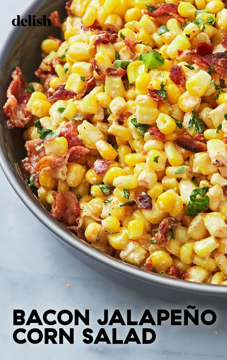 a bowl filled with corn and bacon on top of a table