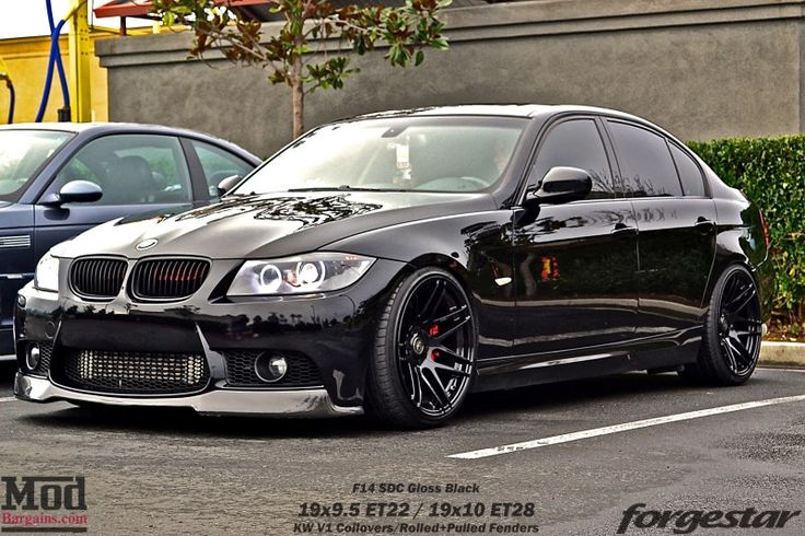 a black bmw is parked in a parking lot