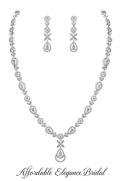 an elegant necklace and earrings set with cubicles on the side, in white gold