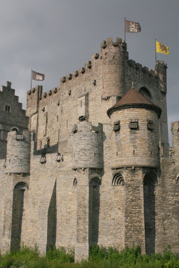 an old castle with flags flying in the wind