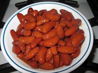 a white bowl filled with cooked carrots on top of a stove