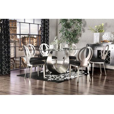 a dining room table with chairs and a rug on the floor in front of it