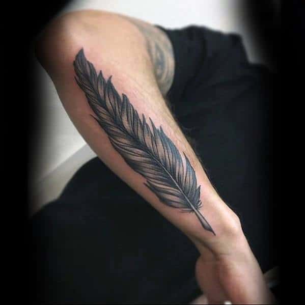 a man with a feather tattoo on his arm