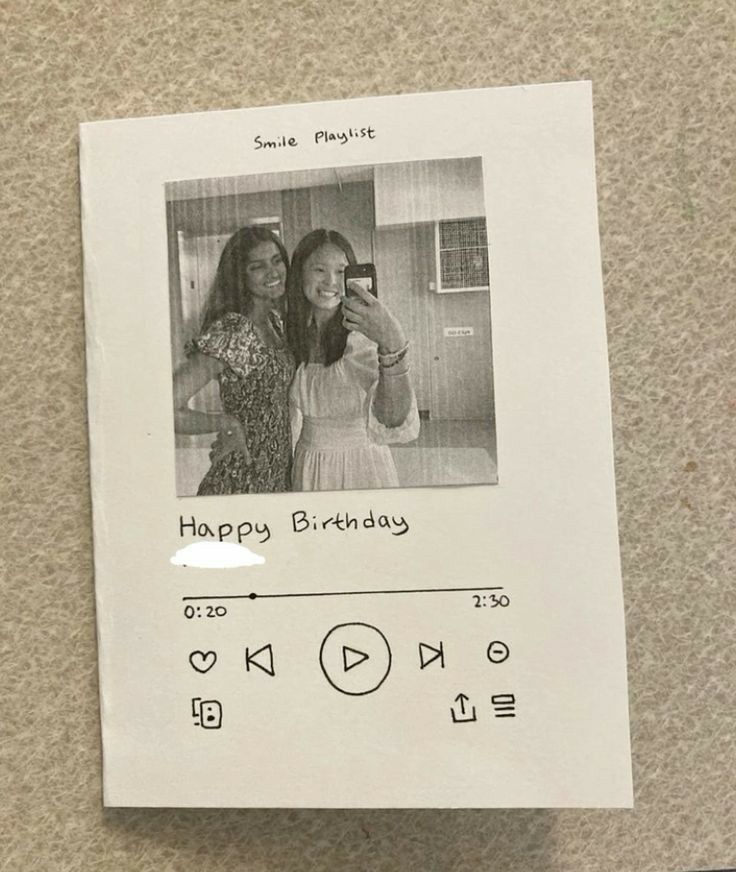 two women taking a selfie in front of a photo on a paper with the words happy birthday