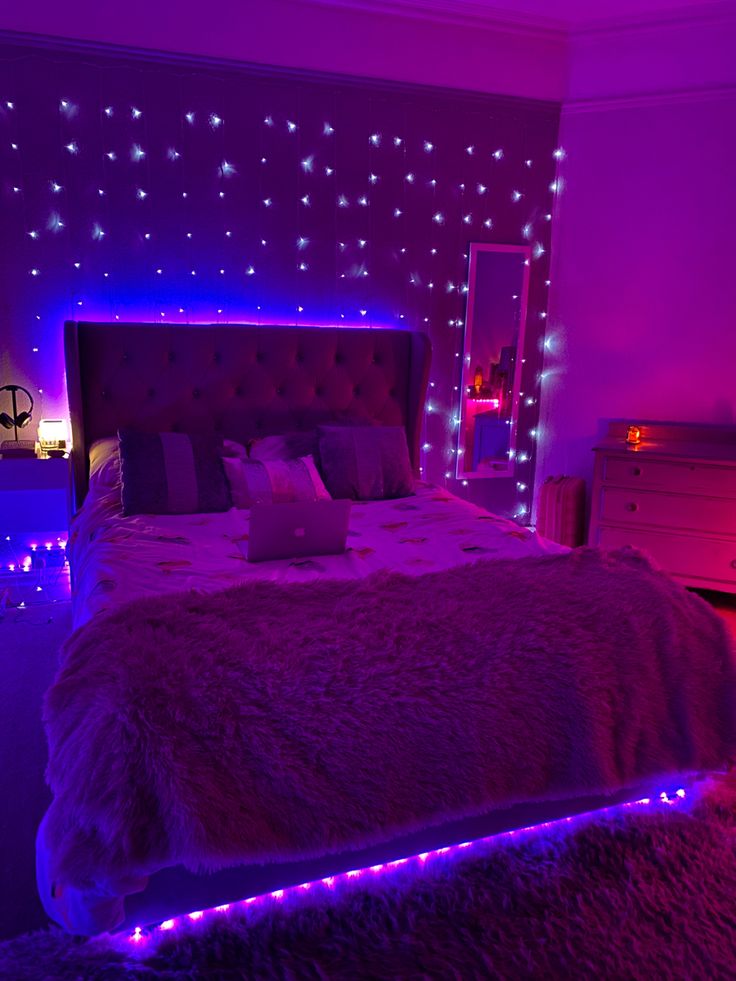 a bed with purple lights in a bedroom