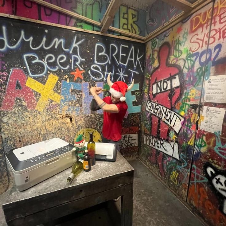 a room with graffiti on the walls and writing on the wall, including a printer