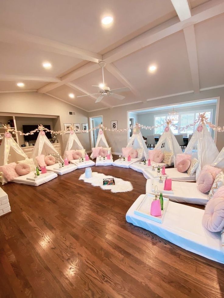 a living room filled with lots of pillows and teepees on top of wooden floors