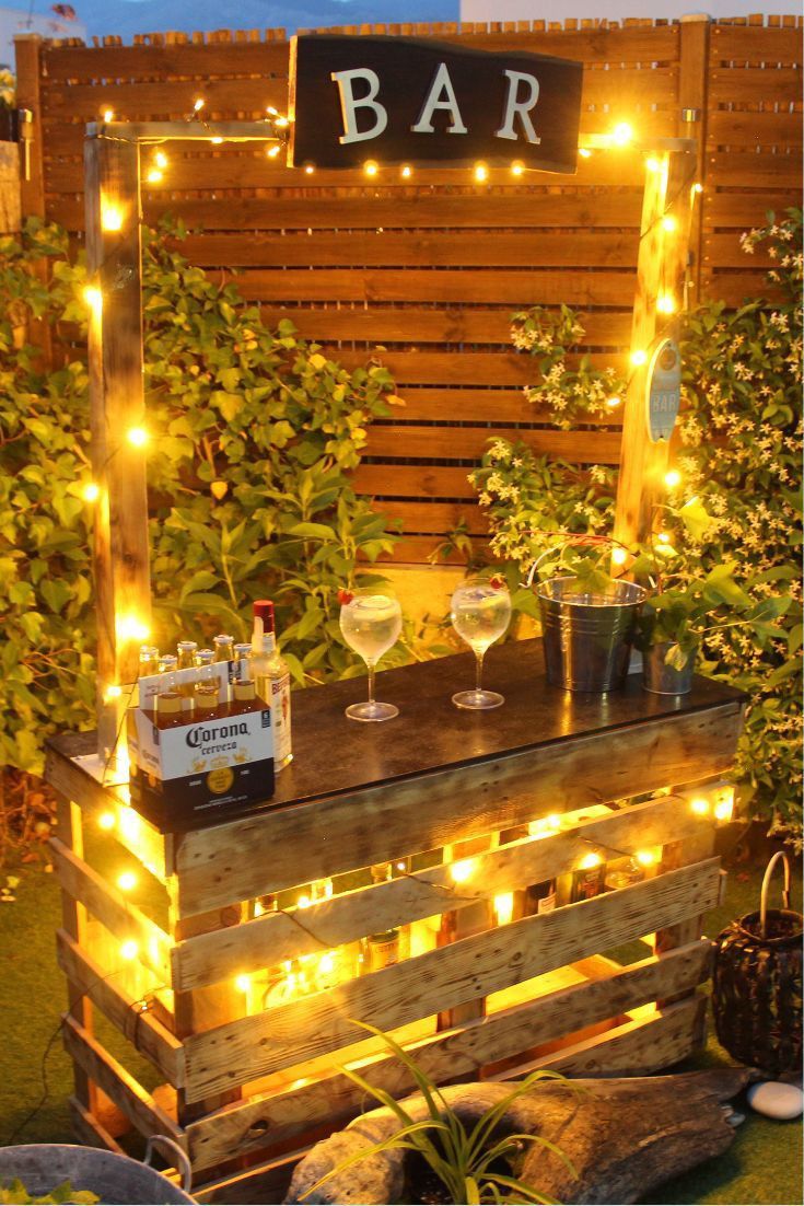 an outdoor bar made out of pallets with lights