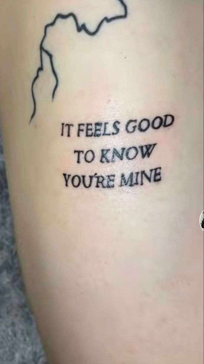 a tattoo saying it feels good to know you're mine