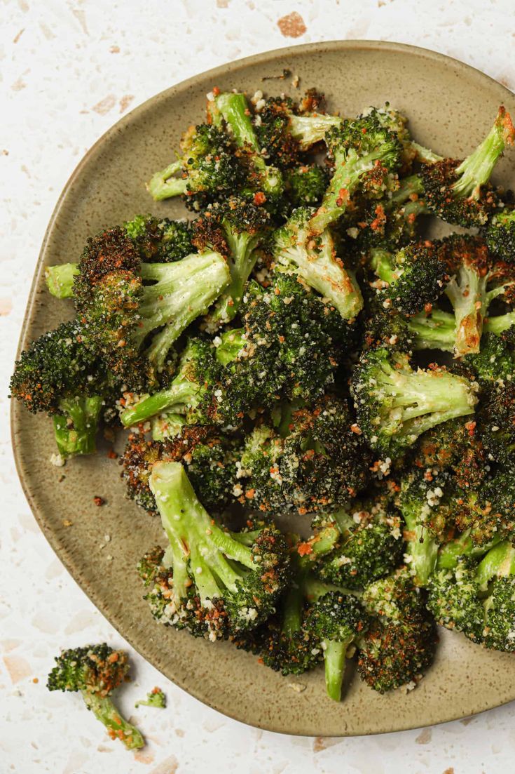 a plate full of broccoli florets with seasoning sprinkles