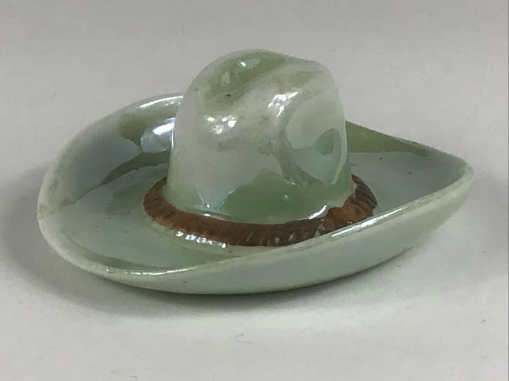 a small green hat sitting on top of a white plate