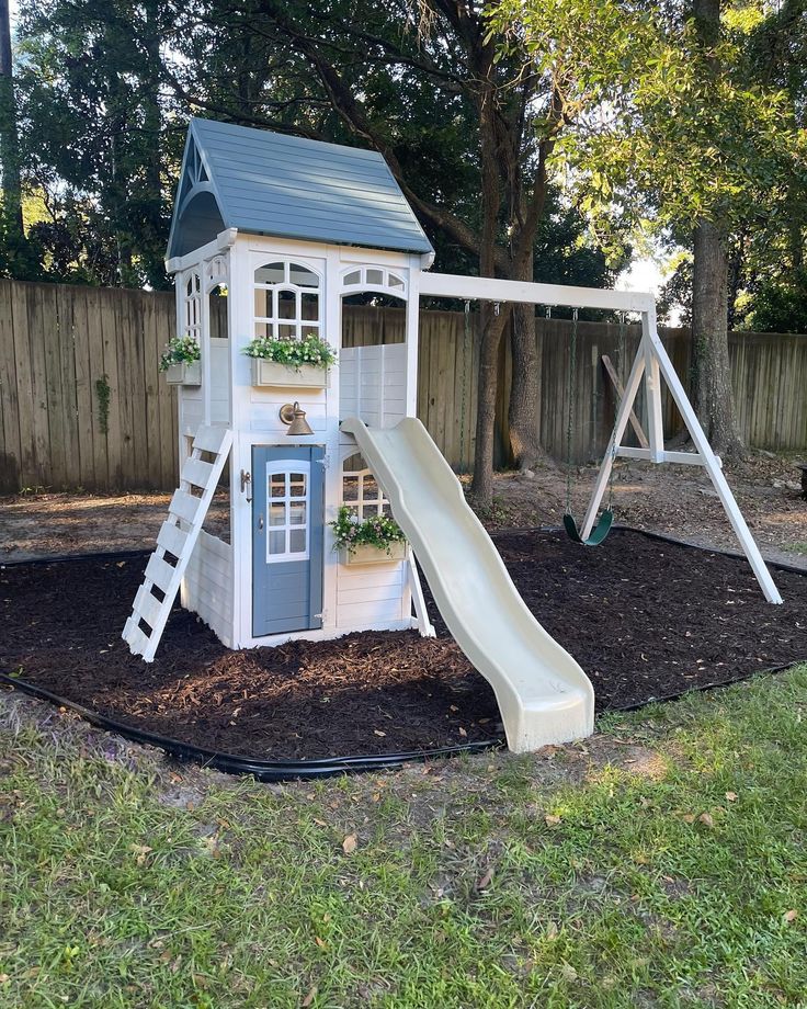 a play house with a slide and climbing frame