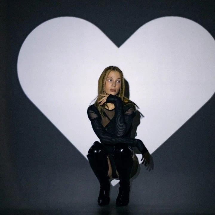 a woman sitting in front of a white heart