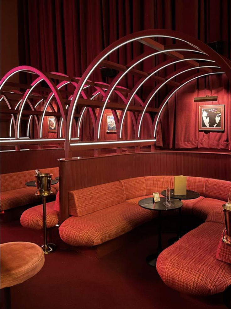 a room with red walls and furniture in the center, along with an arch shaped seating area