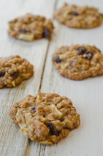 oatmeal and raisin cookies are arranged on a white wooden surface, ready to be eaten