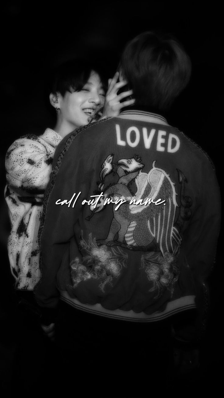 black and white photograph of two people hugging each other with the words loved written on their back