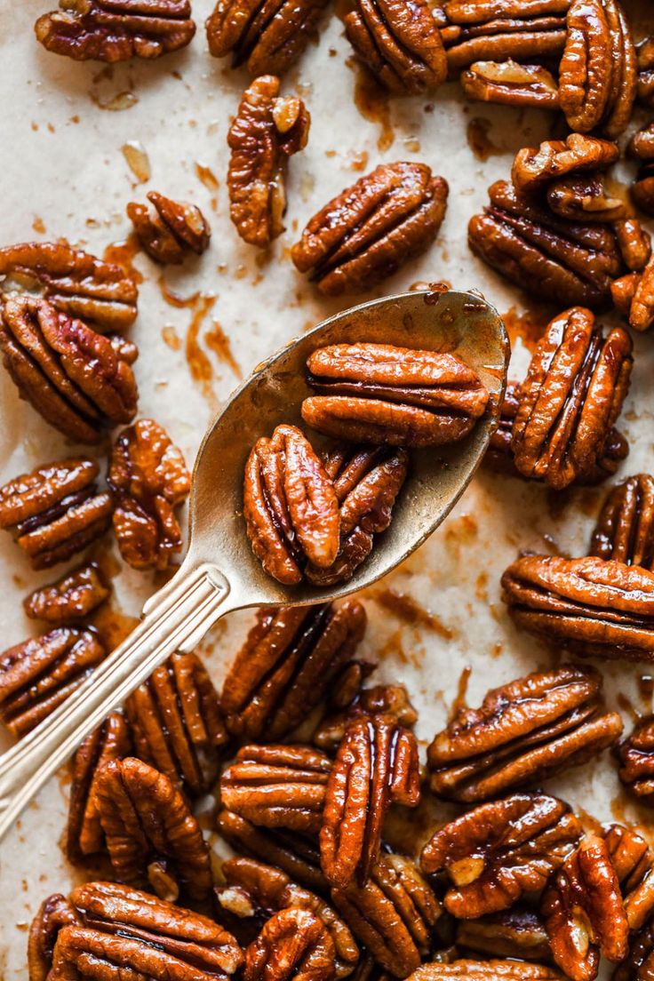 a spoon full of pecans sitting on top of a table