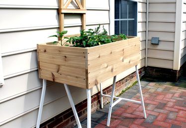 a wooden planter sitting on the side of a house