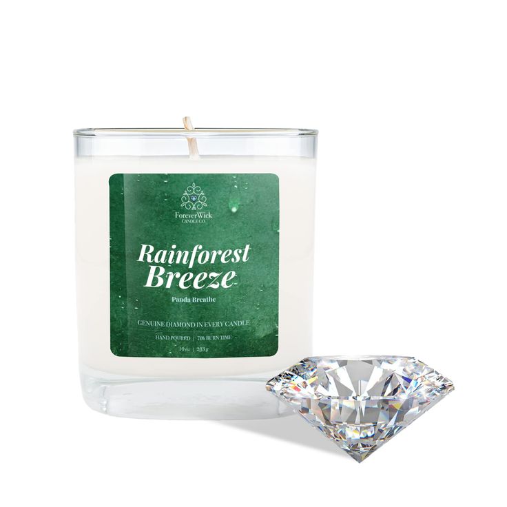 a candle with a diamond next to it on a white surface and a green label that says rainforest breeze