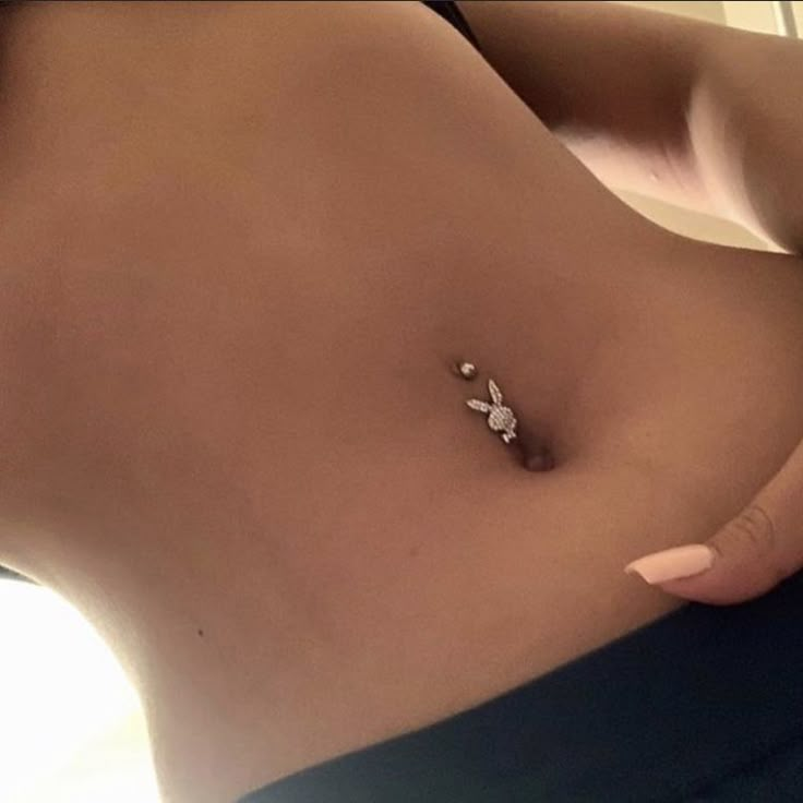 a close up of a person's stomach with a piercing on it