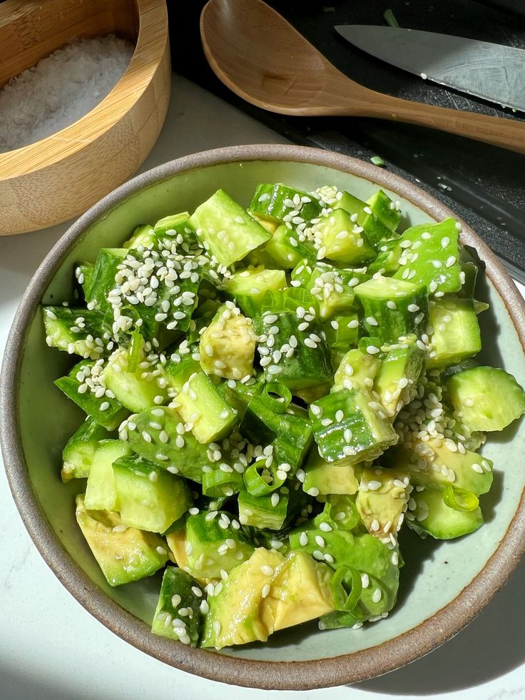 a bowl filled with cucumber and sesame seeds