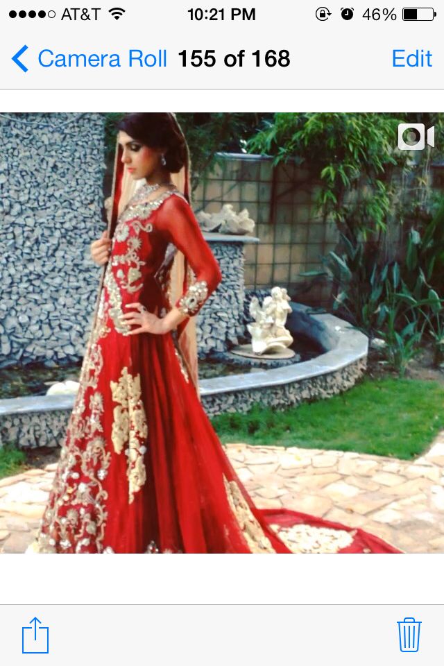 a woman in a red and gold gown standing on a stone walkway with her hands on her hips