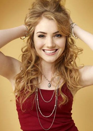 a beautiful young woman in a red dress posing with her hands on her head and smiling at the camera