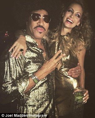 the man and woman are posing together for a photo in their disco outfits, one is holding her arm around the other's shoulder