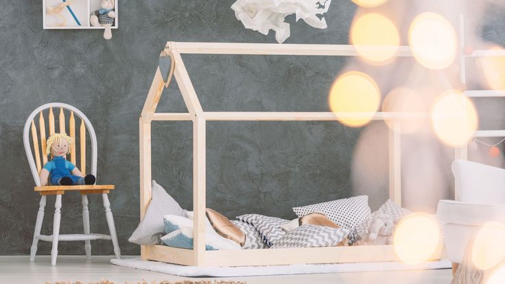 a child's bedroom with a doll house bed and chair in the foreground