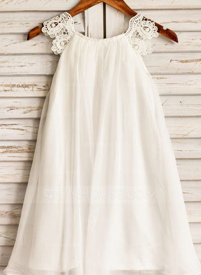 a white dress hanging on a wooden hanger