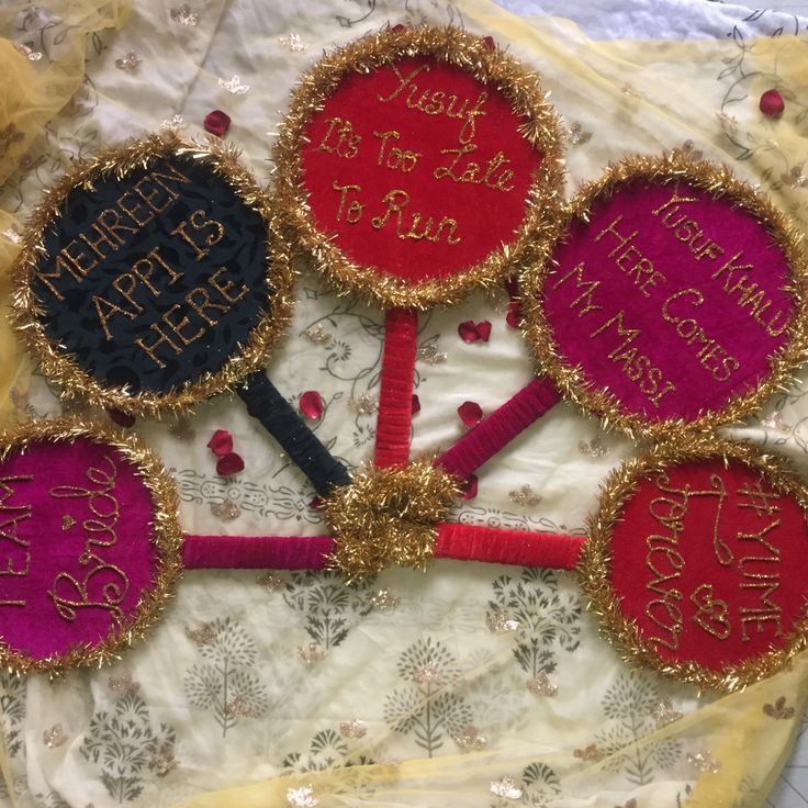 there are five handmade happy birthday cookies on the doily, and one is decorated with gold thread