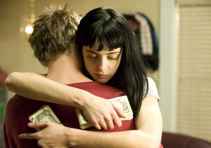 two people hugging each other with money in their arms