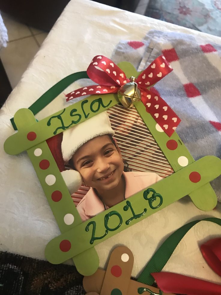 a child's christmas ornament with a santa hat and ribbon on it