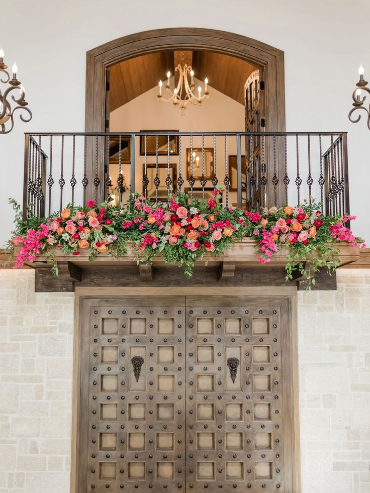 an ornate balcony with flowers and chandelier above the entrance to a home in arizona