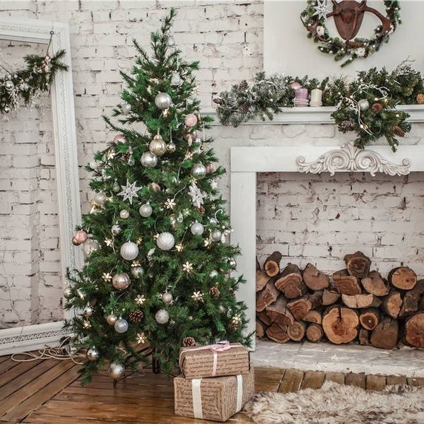 a decorated christmas tree in front of a fireplace